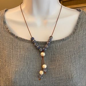 Leather knotted cord necklace with fresh water pearls and blue stones.